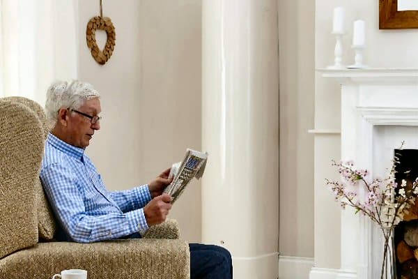 man in armchair reading magazine